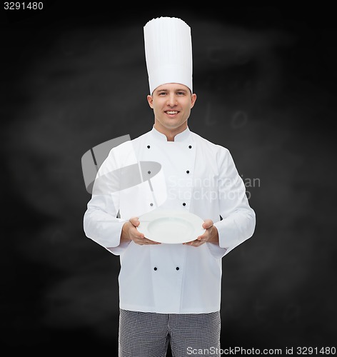 Image of happy male chef cook showing empty plate