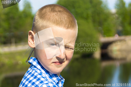 Image of Ten year boy squints in the sun