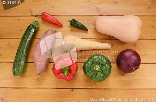Image of Selection of raw vegetables on a wooden table