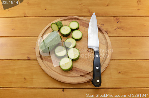 Image of Courgette sliced with a knife on a chopping board