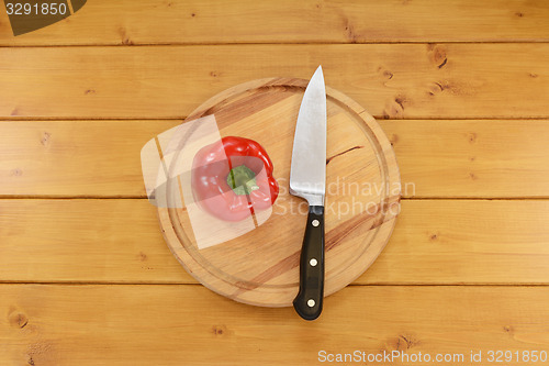 Image of Red pepper with a knife on a chopping board