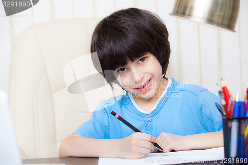 Image of child doing homework with computer, portrait