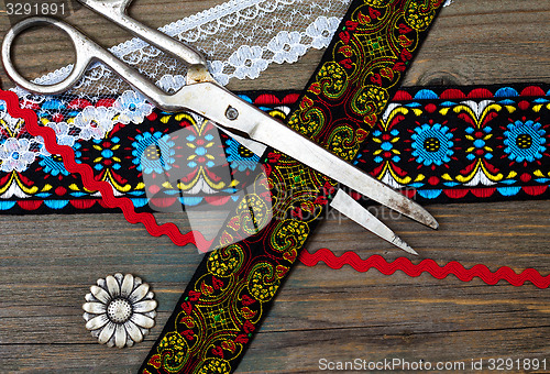 Image of old scissors, antique ribbons and flower buttons