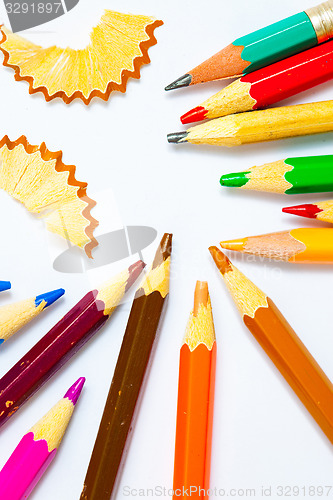 Image of several colored pencils and shavings on white background