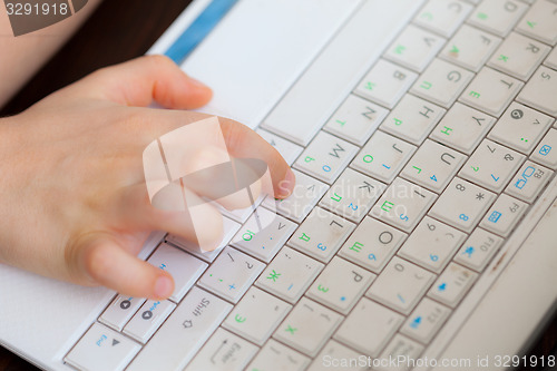 Image of child\'s hand on the laptop keyboard