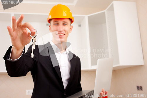 Image of civil engineer with a laptop gives the keys