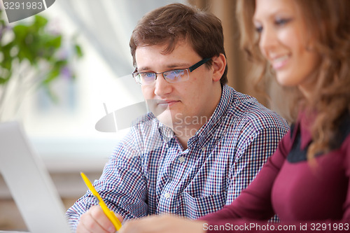 Image of young teacher helping student