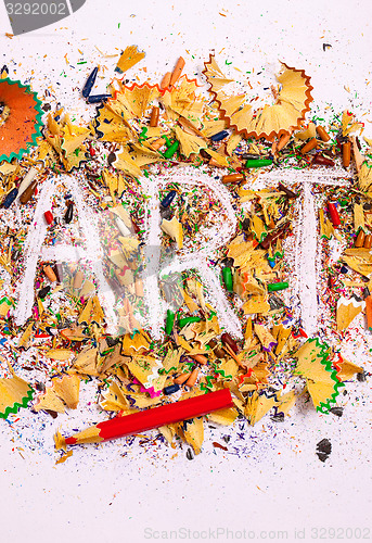 Image of art word on the background of colored pencil shavings