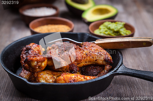 Image of Grilled chicken legs and wings with guacamole