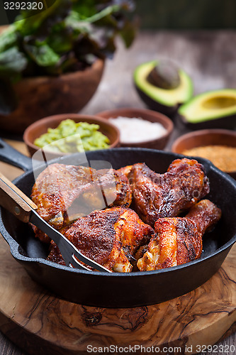 Image of Grilled chicken legs and wings with guacamole