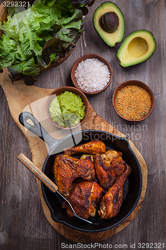 Image of Grilled chicken legs and wings with guacamole