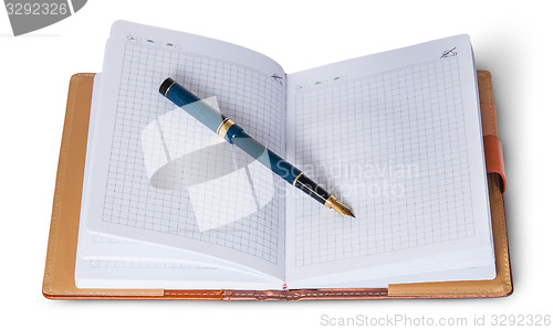 Image of Fountain pen on top of the open notebook