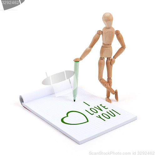 Image of Wooden mannequin writing in scrapbook - I love you