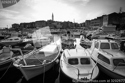 Image of Boats in marina of Rovinj at sunset bw