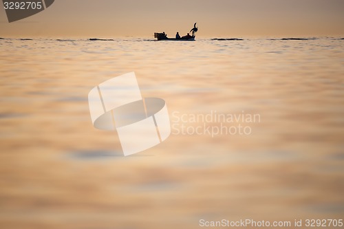 Image of Boat sailing at sunset