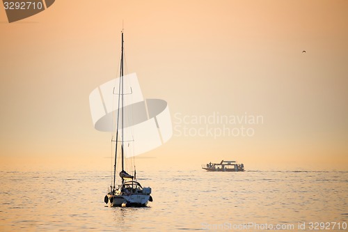 Image of Boats in sea at sunset