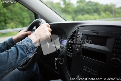 Image of hand of man driving a car