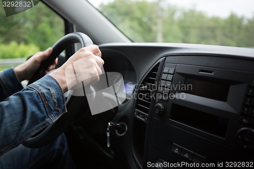 Image of hand of man driving a car