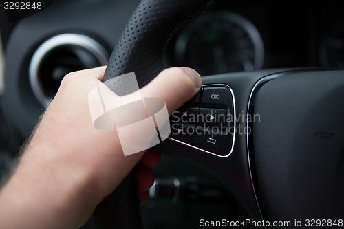 Image of hand of man driving a car