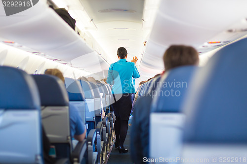 Image of Interior of airplane with passengers on seats.