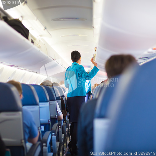 Image of Interior of airplane with passengers on seats.