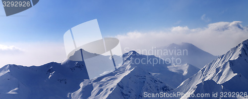 Image of Panorama of snowy mountains in early morning fog