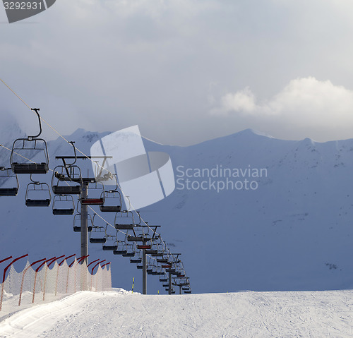 Image of Snow skiing piste and ropeway at evening