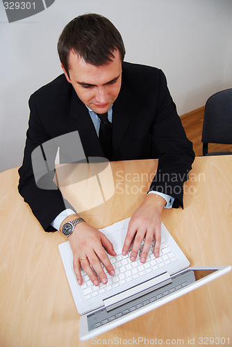 Image of Businessman working on white laptop