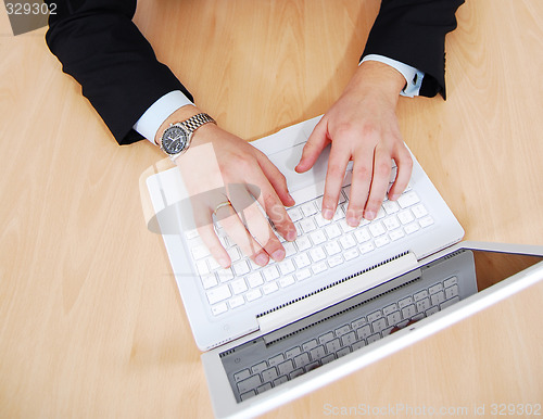 Image of Hands on white laptop