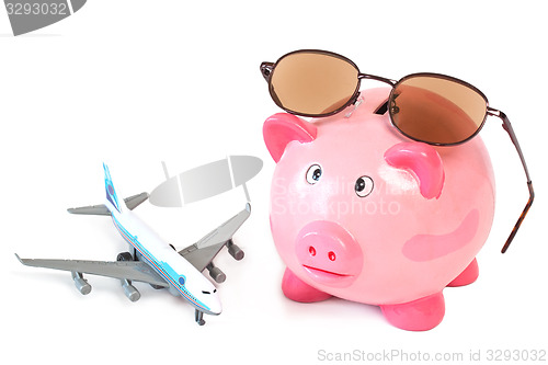 Image of Piggy bank with sunglasses and toy plane