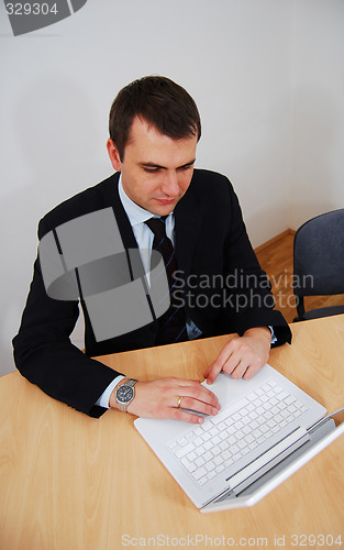 Image of man woirking on white laptop