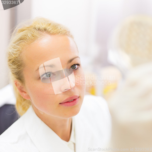 Image of Scientist observing petri dish.