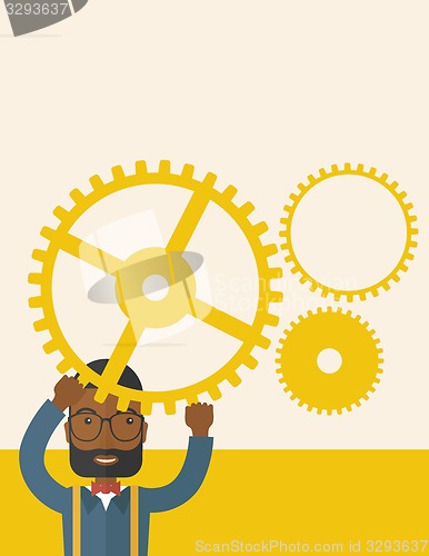 Image of Black buisnesman standing holding up gear.