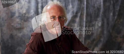 Image of blue eyed man with glasses and grey hair