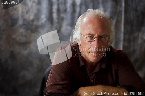 Image of listening blue eyed man with glasses and grey hair