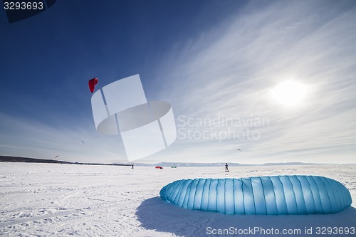 Image of Kiteboarder with blue kite on the snow