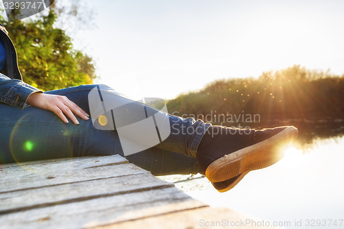 Image of Woman relaxing on jetty