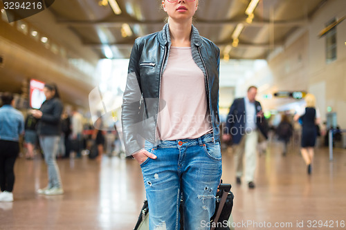 Image of Female traveller walking airport terminal.