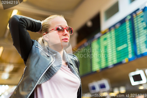 Image of Female traveller checking flight departures board.