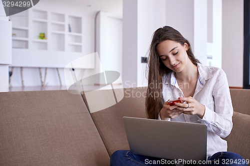 Image of relaxed young woman at home working on laptop computer