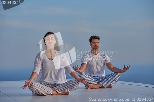 Image of young couple practicing yoga