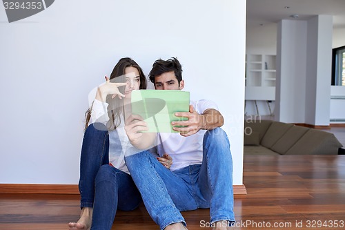Image of couple at modern home using tablet computer