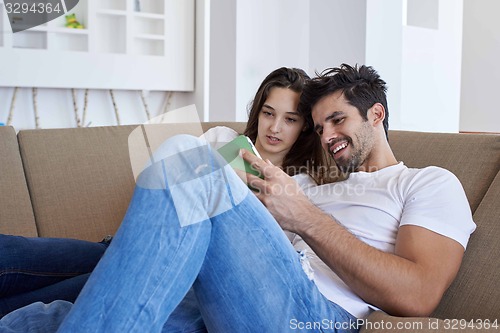 Image of couple at modern home using tablet computer
