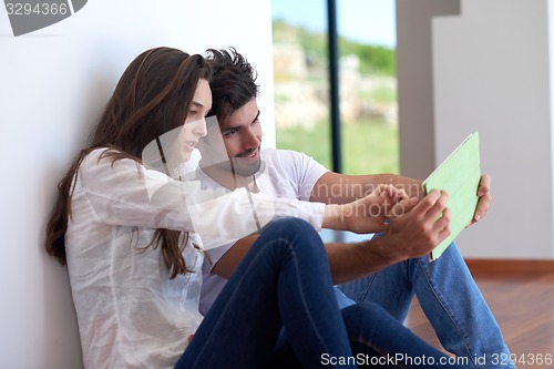 Image of couple at modern home using tablet computer