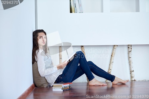 Image of relaxed young woman at home working on laptop computer