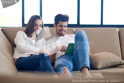 Image of couple at modern home using tablet computer