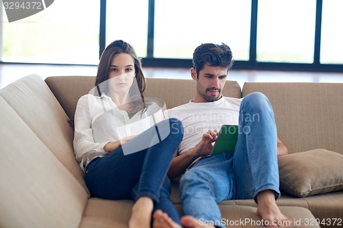 Image of couple at modern home using tablet computer
