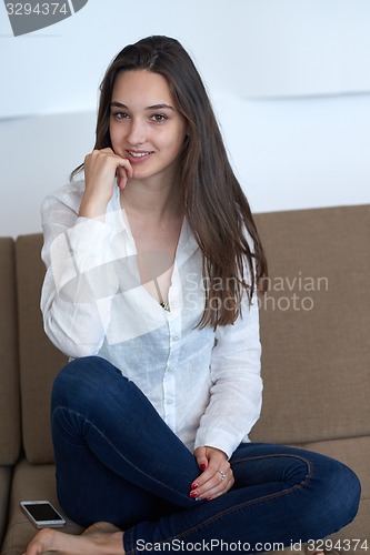 Image of relaxed young woman at home working on laptop computer