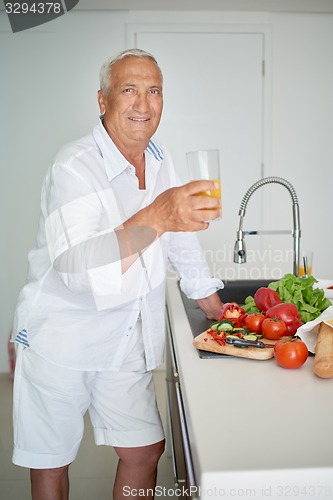Image of man cooking at home preparing salad in kitchen