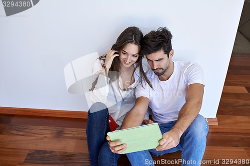 Image of couple at modern home using tablet computer